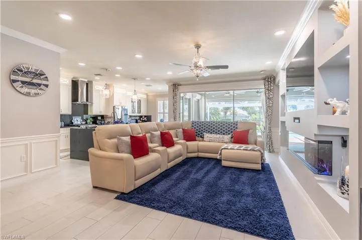 Living room featuring ceiling fan and ornamental molding