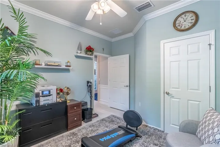 Living area with ornamental molding, light hardwood / wood-style flooring, and ceiling fan