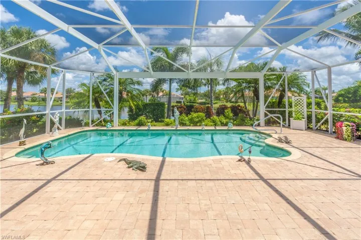 View of swimming pool with glass enclosure and a patio area