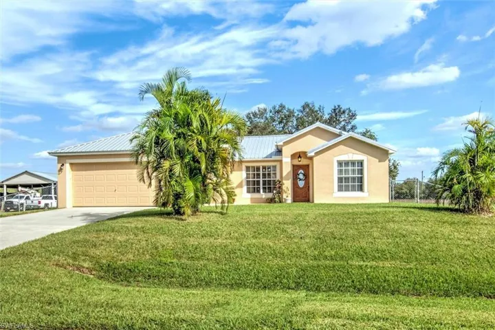 Ranch-style home with a front lawn and a garage