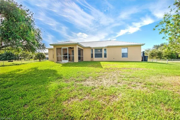 Rear view of house featuring a lawn
