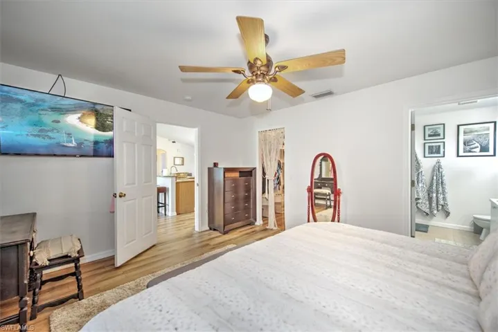 Bedroom featuring ensuite bathroom, ceiling fan, and light hardwood / wood-style floors