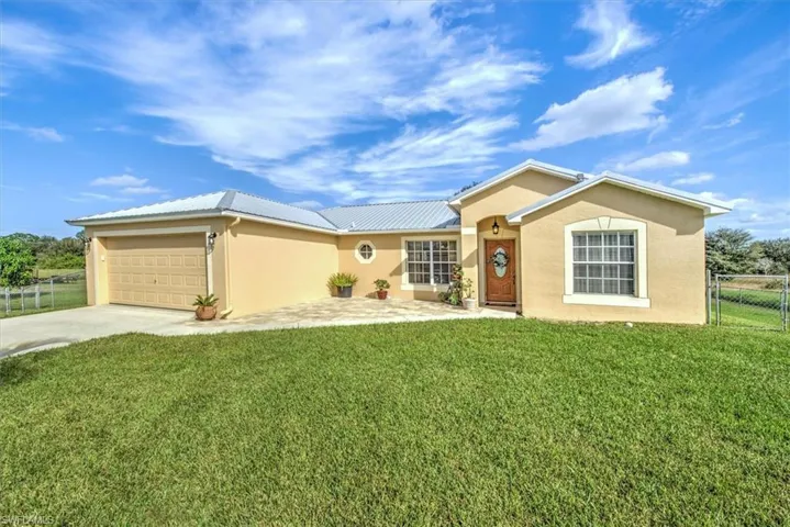 Single story home with a garage and a front yard