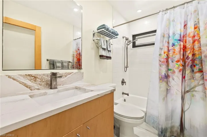 Full bath with vanity, shower / tub combo, and recessed lighting