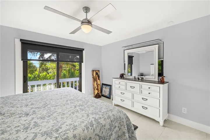 Bedroom featuring multiple windows, access to outside, a ceiling fan, and light tile patterned flooring