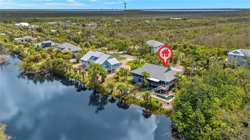 Aerial perspective of suburban area with a large body of water and a heavily wooded area