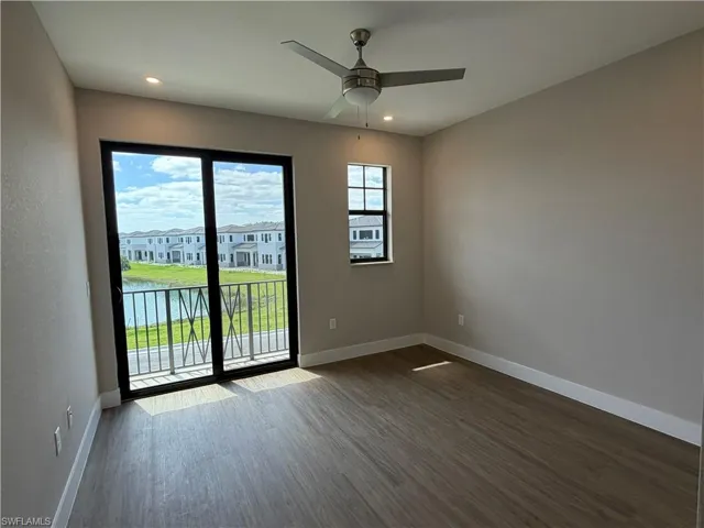 This room features wood-look flooring, a ceiling fan with integrated lighting, and recessed lighting