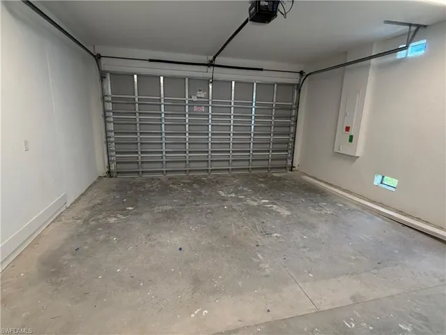 The property features a 2 car garage with a roll-up door and a concrete floor