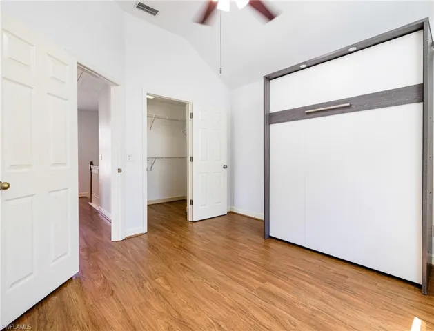 Third floor guest bedroom with vaulted ceilings and walk in closet.