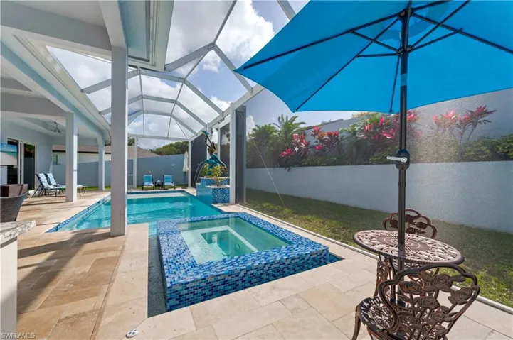 View of swimming pool with a sunroom, a patio area, a lanai, a fenced backyard, and a pool with connected hot tub