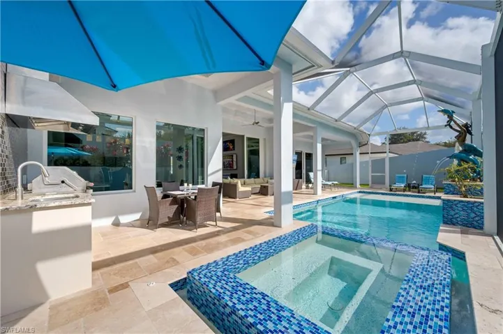 View of swimming pool with a sunroom, a patio area, an outdoor living space, outdoor dining area, and a pool with connected hot tub