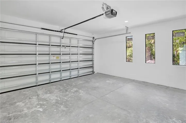 Garage featuring a garage door opener and recessed lighting