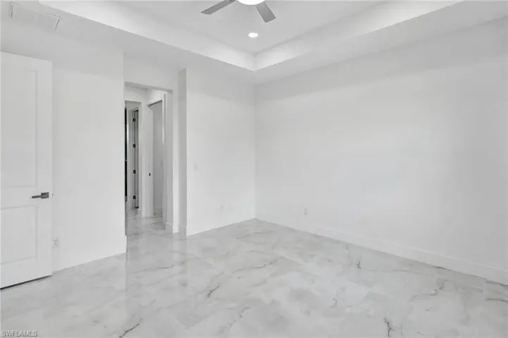 Spare room featuring a ceiling fan, recessed lighting, and light marble finish floors