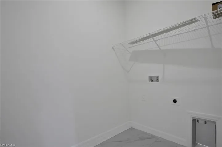 Laundry area with hookup for a washing machine, light marble finish flooring, and electric dryer hookup