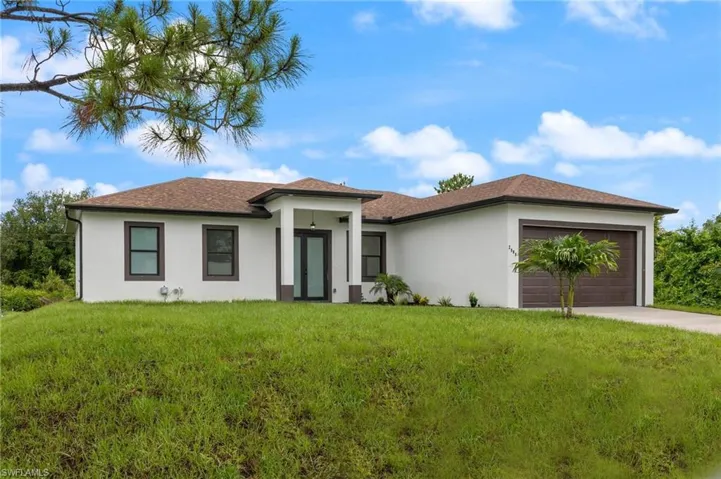 View of front facade with a front yard and a garage