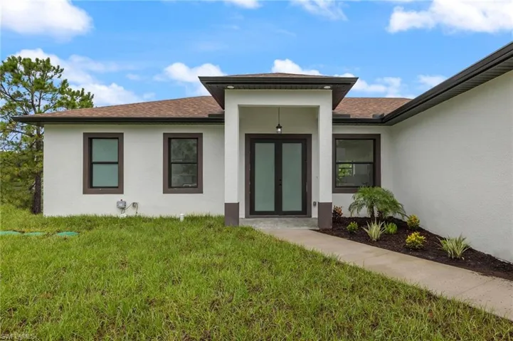 Entrance to property with a lawn