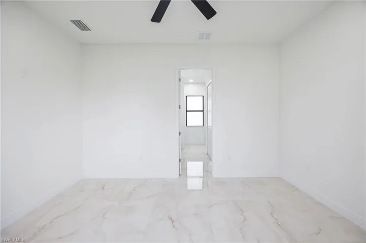 Tiled empty room featuring ceiling fan