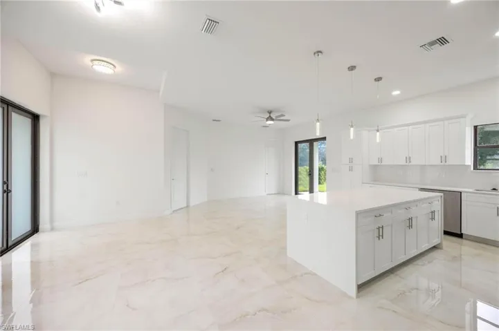 Kitchen featuring a center island, ceiling fan, and light tile floors