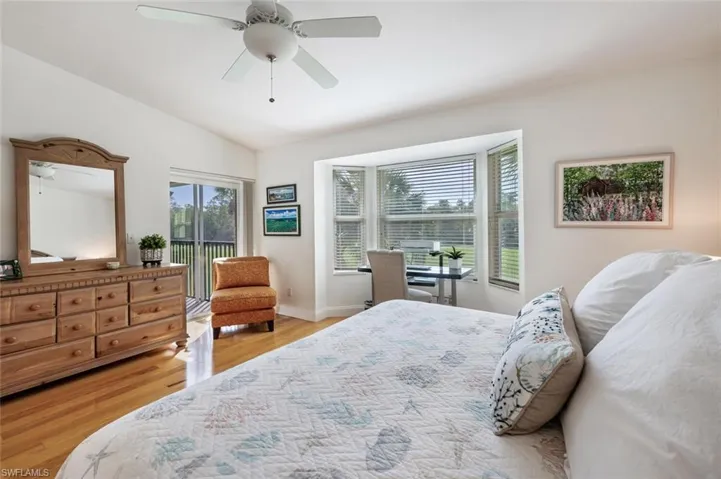 Bedroom featuring access to exterior, light wood-style floors, vaulted ceiling, and a ceiling fan