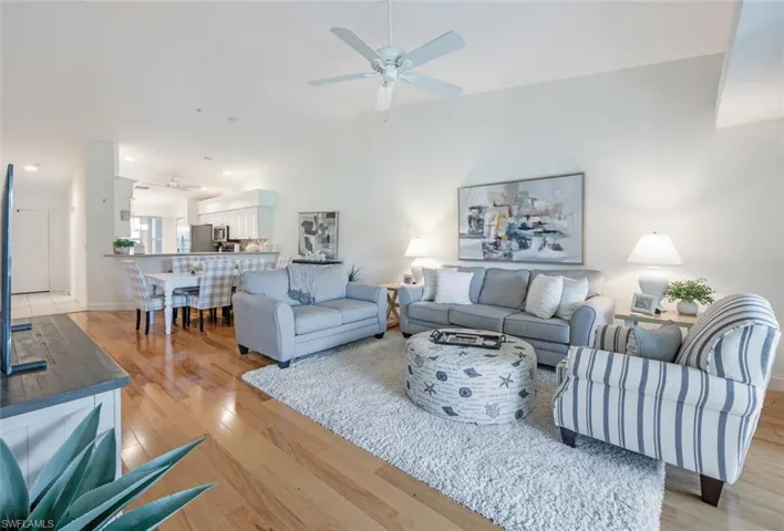 Living area with a ceiling fan, vaulted ceiling, light wood-type flooring, and recessed lighting