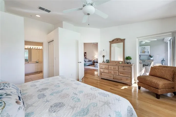 Bedroom featuring wood finished floors, ceiling fan, and connected bathroom
