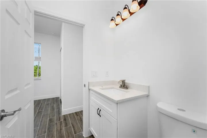 Half bath with vanity and wood tiled floors