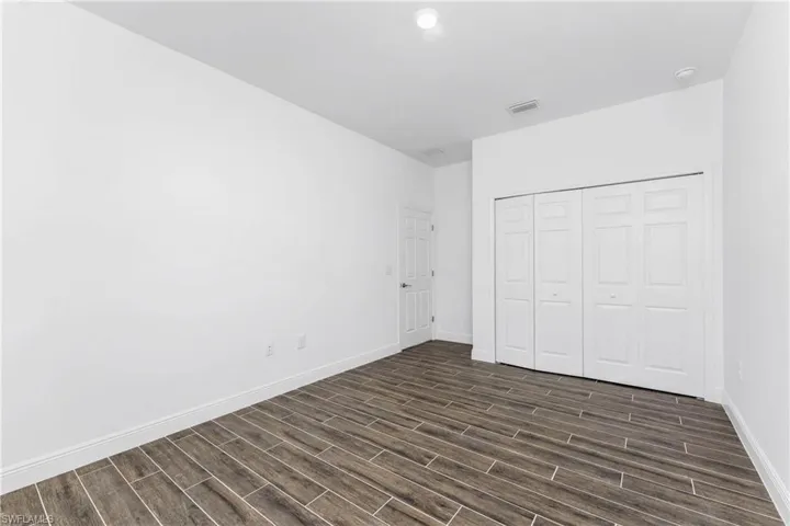 Unfurnished bedroom with wood finish floors and a closet