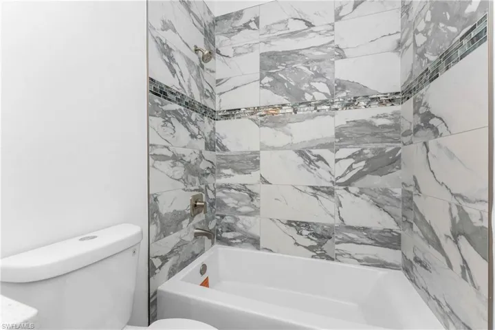 Bathroom featuring toilet and bathing tub / shower combination