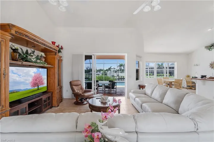 Living area featuring a ceiling fan, healthy amount of natural light, and tile patterned floors