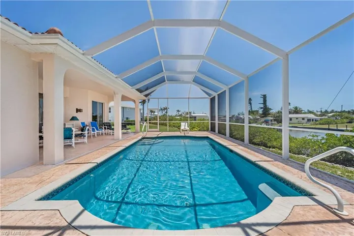 Outdoor pool featuring a patio and glass enclosure