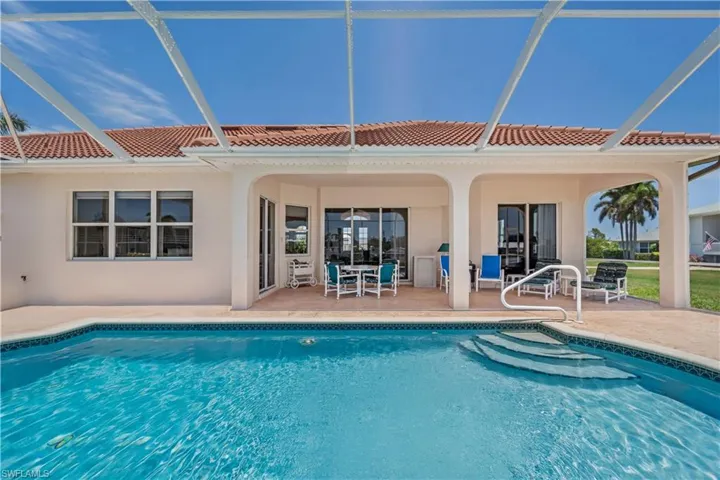 Outdoor pool with a patio area and glass enclosure