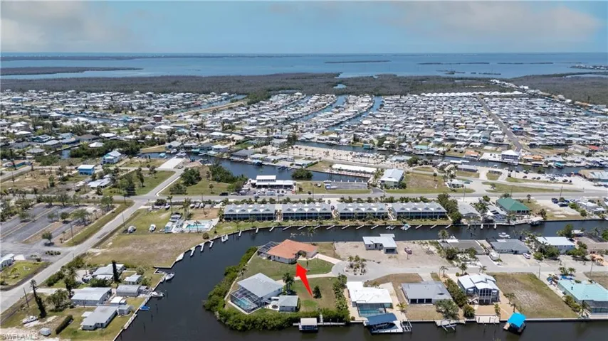 Aerial view of property and surrounding area with a nearby body of water and nearby suburban area