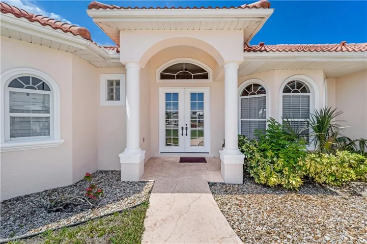 Entrance to property with french doors, stucco siding, and a tile roof