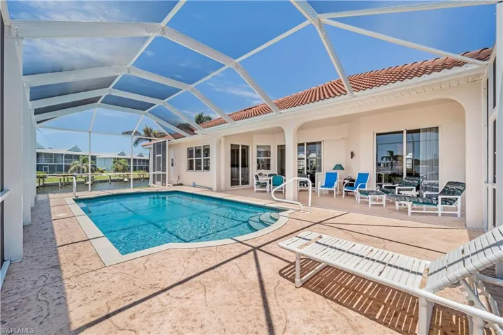 Swimming pool featuring a patio area and glass enclosure