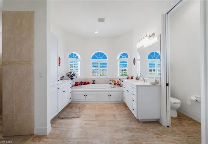 Full bathroom with vanity, toilet, a garden tub, and recessed lighting