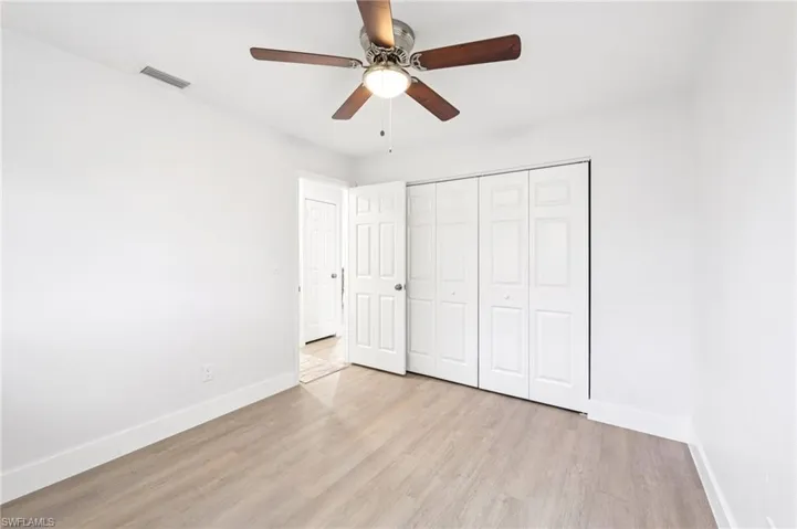 Unfurnished bedroom featuring light wood finished floors, a ceiling fan, and a closet