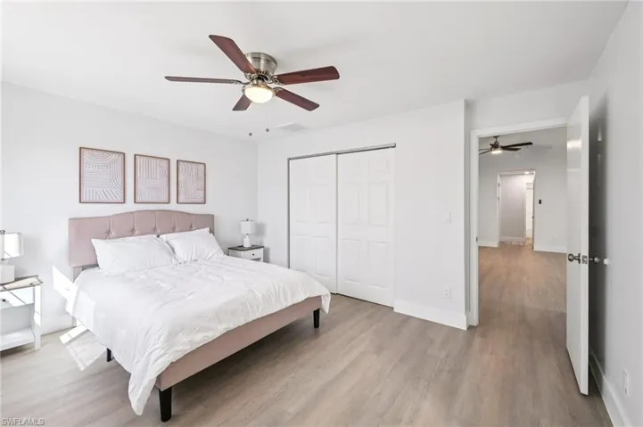 Bedroom with wood finished floors, a closet, and ceiling fan
