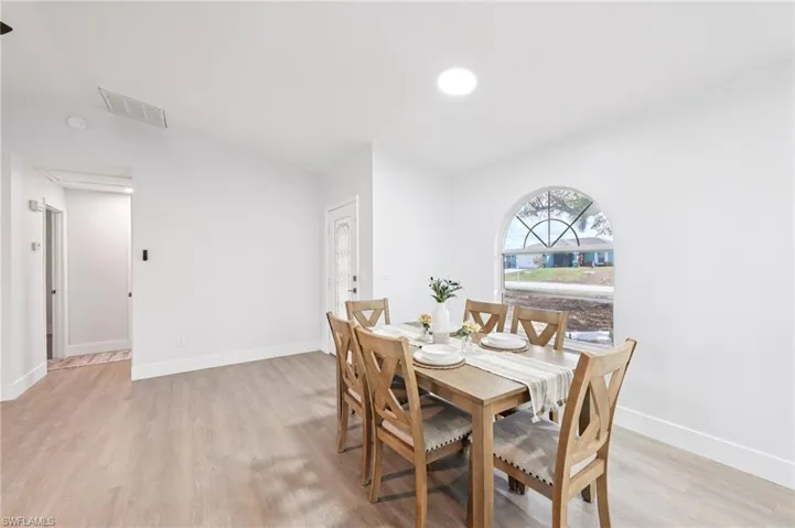Dining area featuring light wood-style floors and baseboards