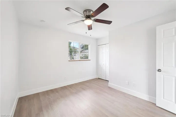 Unfurnished bedroom with light wood-style flooring, a ceiling fan, and a closet