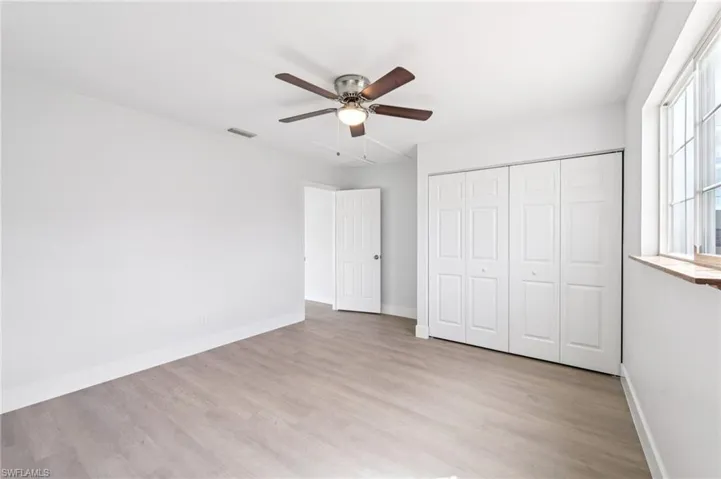 Unfurnished bedroom featuring light wood-type flooring, a ceiling fan, and a closet