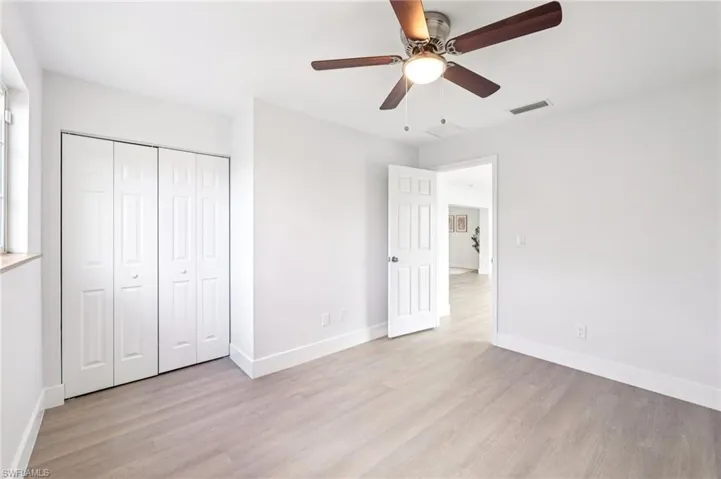 Unfurnished bedroom with light wood finished floors, a ceiling fan, and a closet