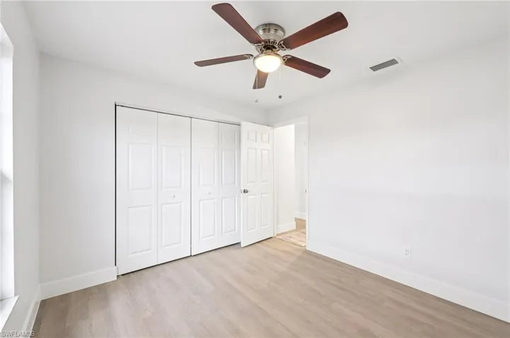 Unfurnished bedroom featuring light wood-style flooring, ceiling fan, and a closet