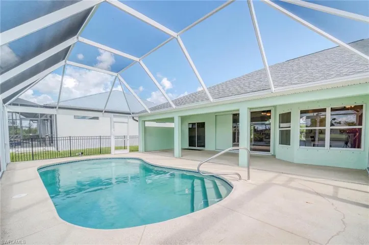 View of swimming pool featuring a patio and glass enclosure