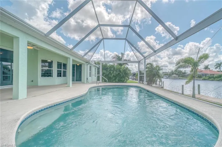 View of pool with ceiling fan, a patio area, and a lanai