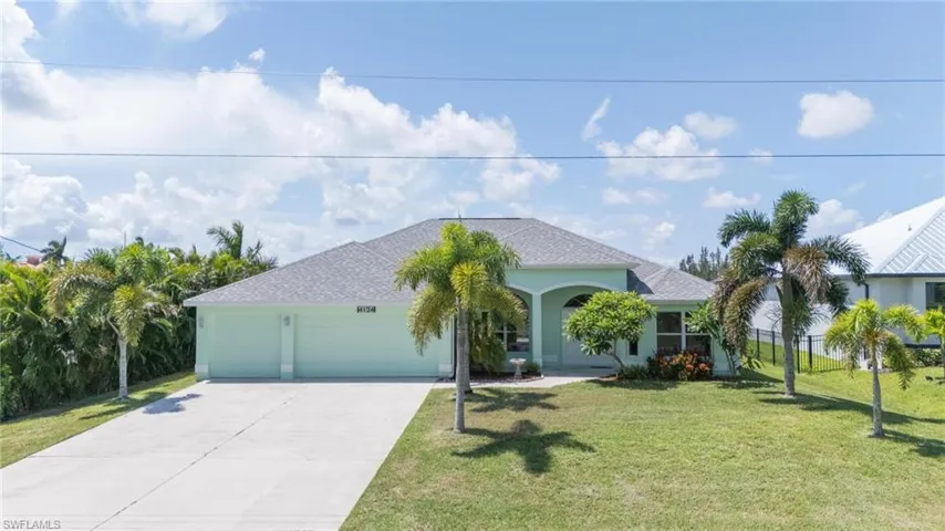 View of front of house with a front lawn and a garage