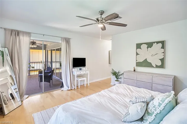 Bedroom with wood finished floors, access to outside, and ceiling fan