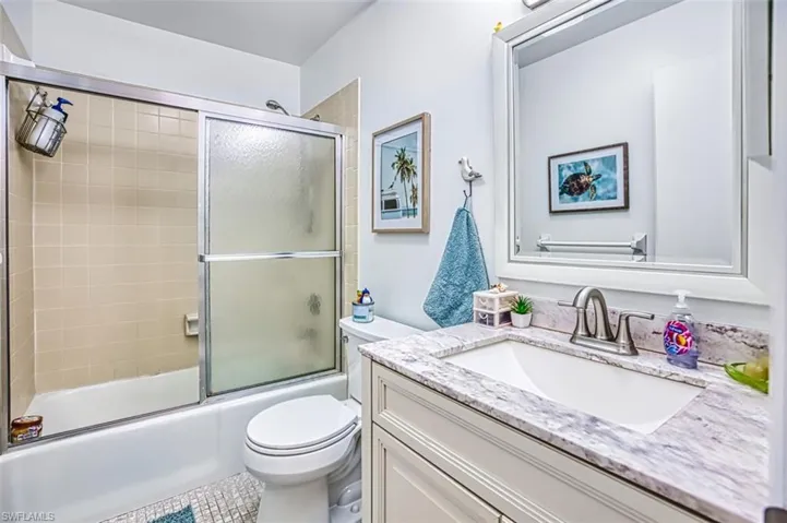Bathroom featuring vanity and combined bath / shower with glass door