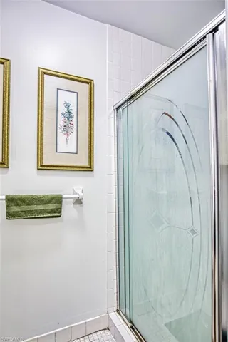 Bathroom featuring a shower stall and tile patterned flooring