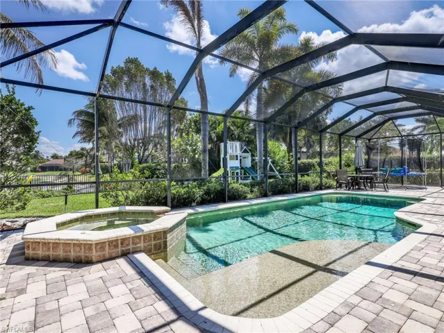Integrated pool / hot tub with a lanai, a sunroom, a patio area, and outdoor dining space