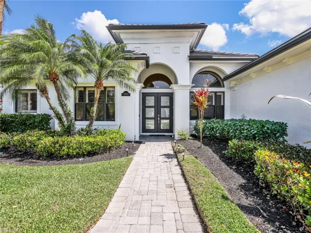 Entrance to property featuring french doors, stucco siding, and a lawn